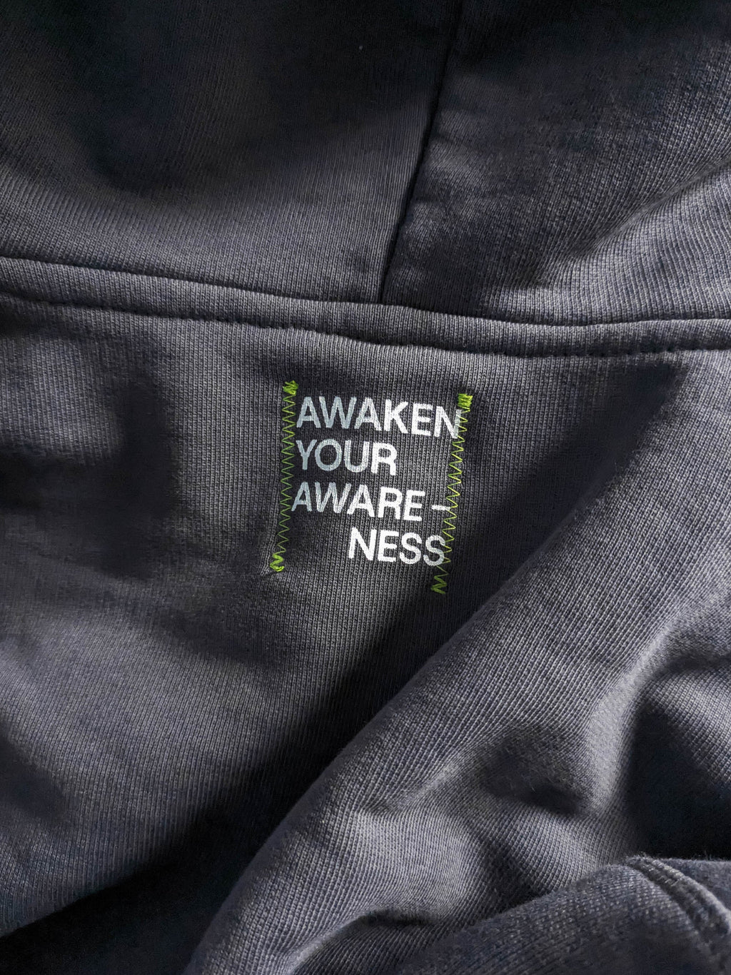 Text label on a gray fabric with a moto.